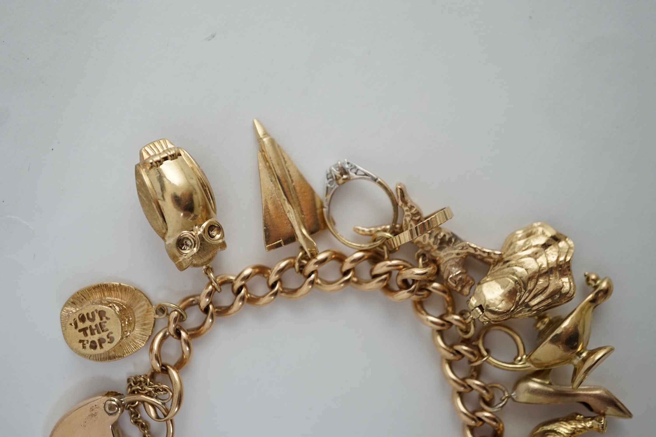 An early 20th century 15ct gold curb link charm bracelet